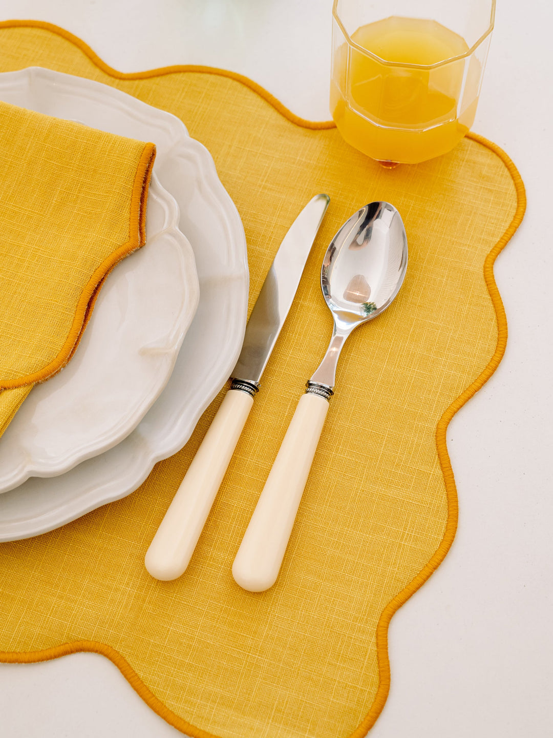 Palma stain-resistant placemat in yellow and yellow scalloped edge
